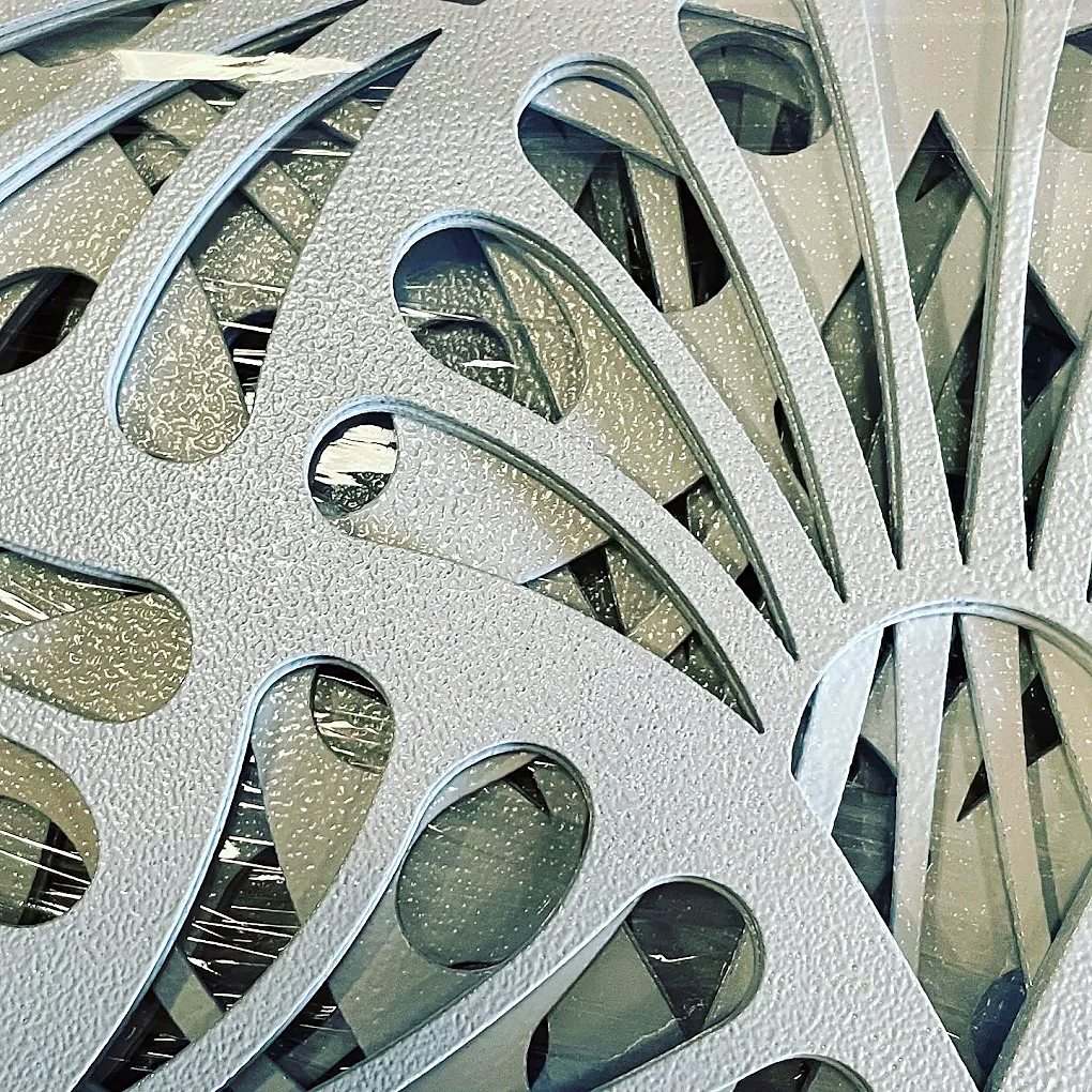 Laser-cut aluminium facade panel with leaf pattern, textured white powder coat