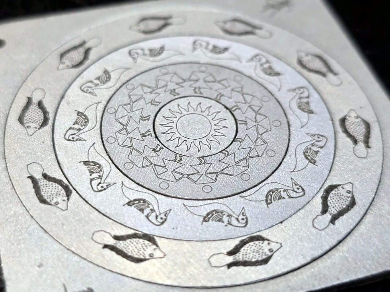Fine mandala and fish motif laser-engraved on a stainless steel plate